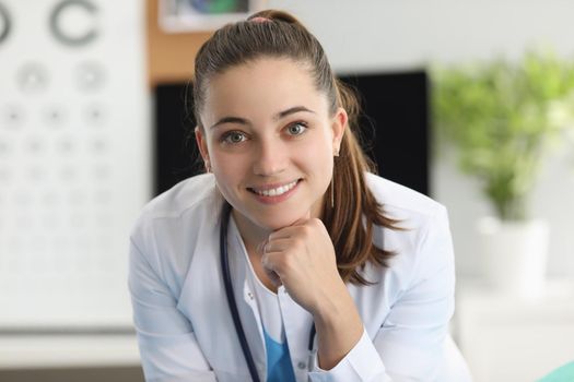 Portrait of smiling woman ophthalmologist in office of clinic