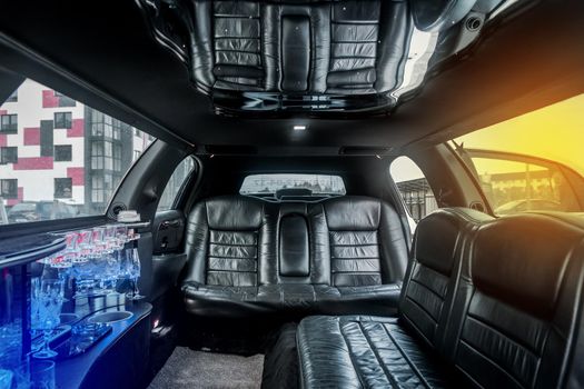 Luxury car interior limousine with black leather seats and a small bar inside the interior of the car