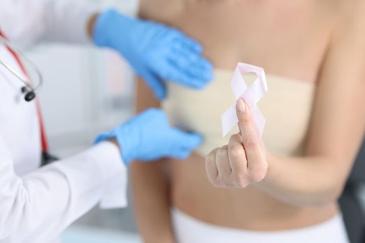 Gynecologist conducts medical examination of female breast
