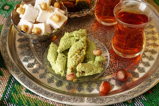 Turkish sweet baklava on metal tray with Turkish tea