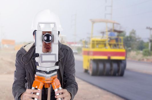 engineer working with survey equipment theodolite with road under construction 