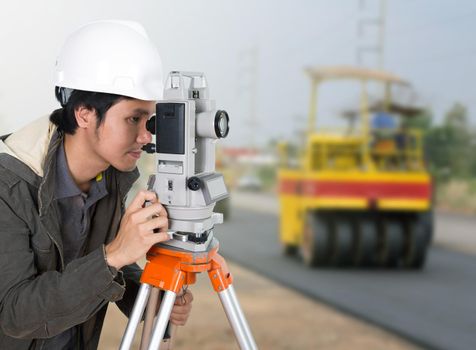 engineer working with survey equipment theodolite with road under construction