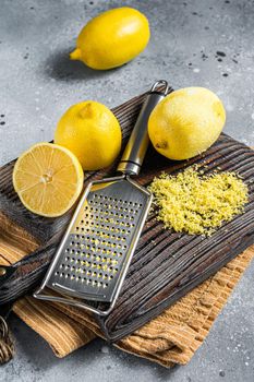 Raw grated Lemon Zest peel on wooden board. Gray background. Top view