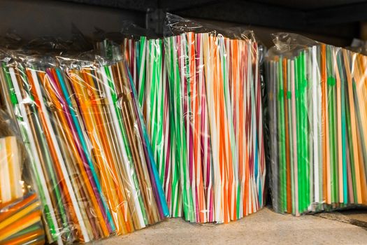 Set of multicolored plastic straws on a shelf in a store close up