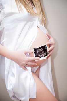 Close up of pregnant woman holding ultrasound scan
