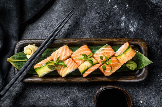 Philadelphia maki sushi with salmon, prawn, avocado, cream cheese. Sushi roll menu. Black background. Top view