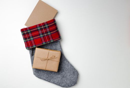 Christmas stocking with wrapped gift on white background