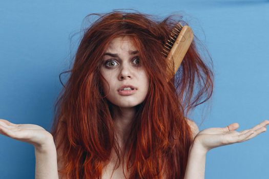 emotional woman combing her messy hair blue background