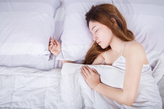 Woman sleeping on bed in bedroom 