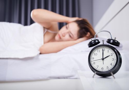 clock with woman sleepless on bed 