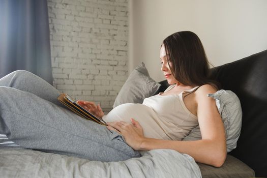 Pregnant Happy Woman using Tablet computer Belly