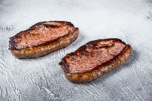 Grilled top sirloin cap or picanha steak. White background. Top view