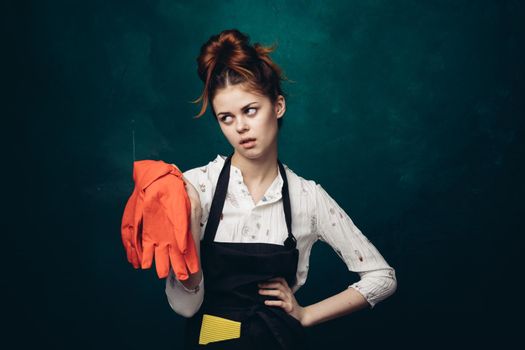 woman with rubber gloves in apron cleaning housework