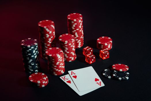 Stack of chips and two cards on dark background - poker game concept