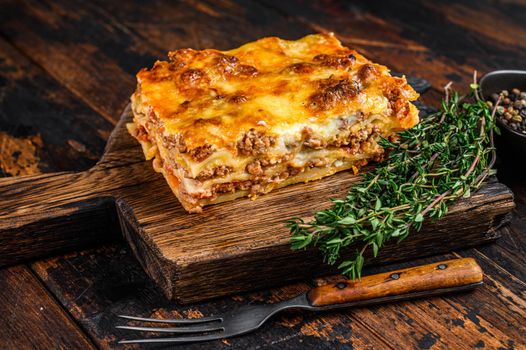 Italian Lasagna with bolognese sauce and mince beef meat. Dark Wooden background. Top view