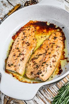 Oven Baked salmon or trout fillet. White woodenbackground. Top view