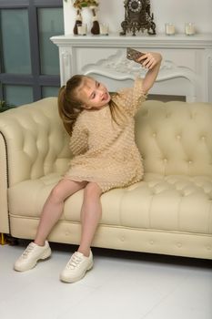 Happy little girl enjoys a smartphone. The concept of people and technology.