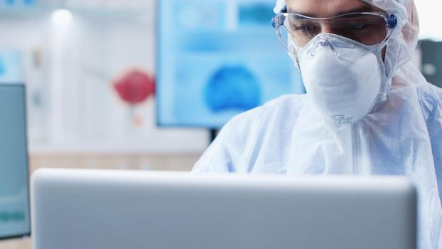 Scientist researcher with ppe equipment analyzing virus expertise typing medical diagnostic