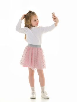 Happy little girl enjoys a smartphone. The concept of people and technology. Isolated on white background.
