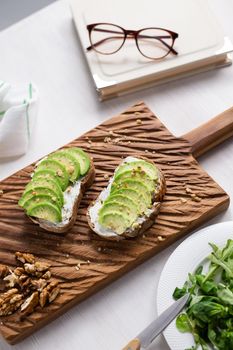 Sliced avocado on toast bread with nuts. Breakfast and healthy food concept.