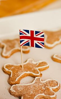 British holiday and Christmas baking concept. Union Jack flag of Great Britain and gingerbread men biscuits in the kitchen in England