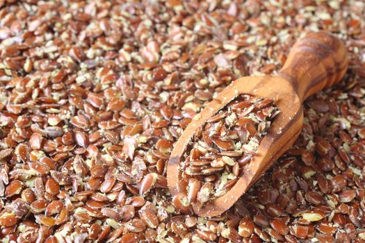 Broken flax seeds in wooden scoops
