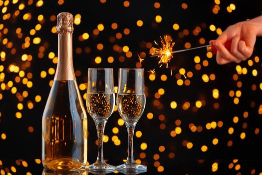 Champagne bottle and glasses on blurred lights background