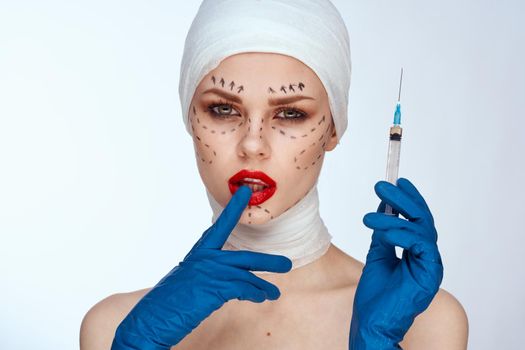 beautiful woman in blue gloves syringe in hands contour on the face lifting isolated background