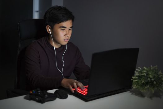 young man using laptop on table at night