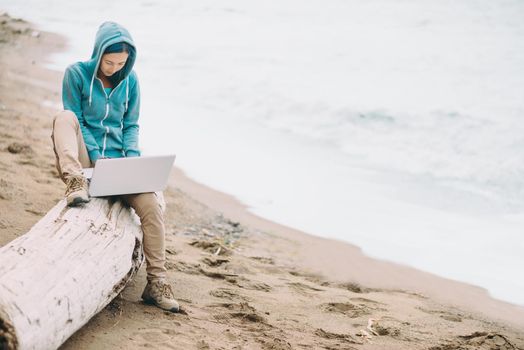 Freelancer working on laptop on beach