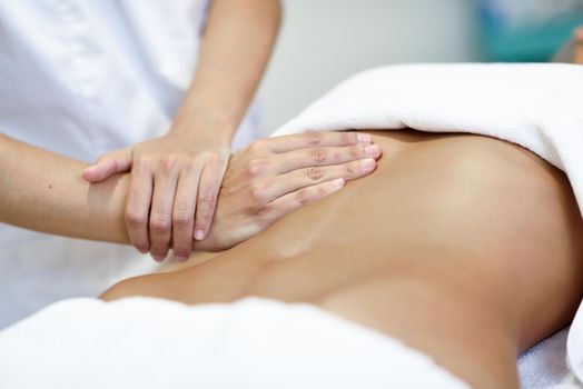 Hands massaging female abdomen.Therapist applying pressure on belly.