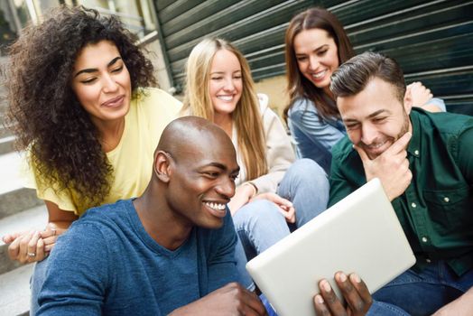 Multi-ethnic group of young people looking at a tablet computer