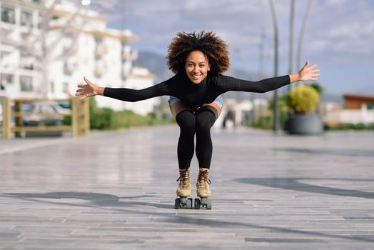 Black woman on roller skates riding outdoors on urban street