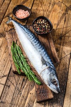 Raw saltwater fish Mackerel on a wooden cutting board with a thyme. wooden background. Top view