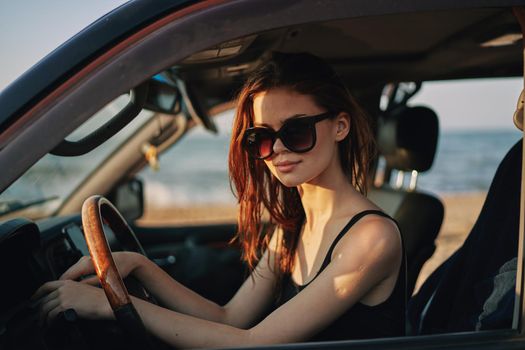 cheerful woman in sunglasses driving a car trip travel. High quality photo