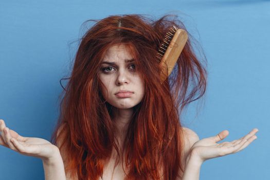 emotional woman combing her messy hair blue background