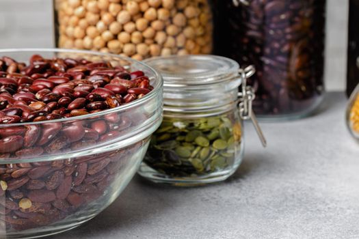 Raw cereals or beans in glass jars close up. Vegan and vegetarian food.