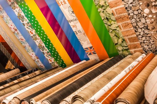 Belarus, Minsk - December 19, 2019: Different samples of color wallpaper material in rolls for interior design in the store