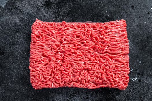 Raw mince beef meat on a kitchen table. Black background. Top view