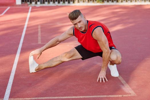 athletic man doing exercises outdoors sports field exercise