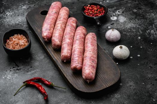Minced meat sausages, on black dark stone table background