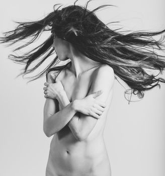 Nude woman with moving hair on white background