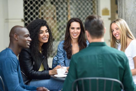 Multiracial group of five friends having a coffee together