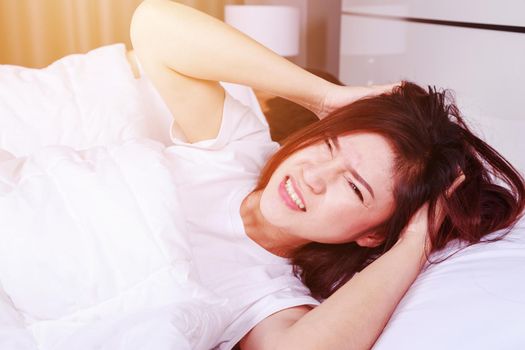 woman having sleepless on bed and having migraine,stress, insomnia, hangover in bedroom