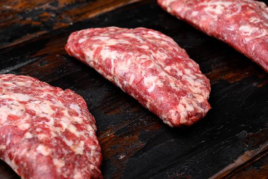 Fresh raw minced homemade farmers grill beef burgers, on old dark wooden table background