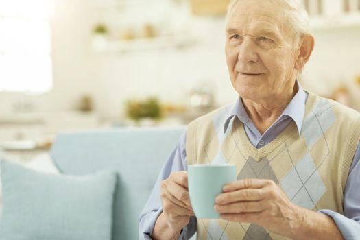 Pensioner relaxing at home with a cup of hot tea