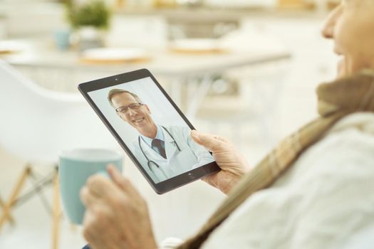 Advanced pensioner using tablet to communicate with doctor
