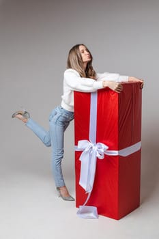 Cheerful girl hugging giant wrapped present.
