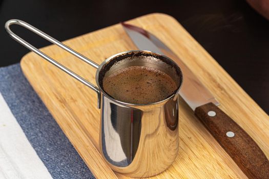 Brewed coffee in a metal turk on a kitchen counter
