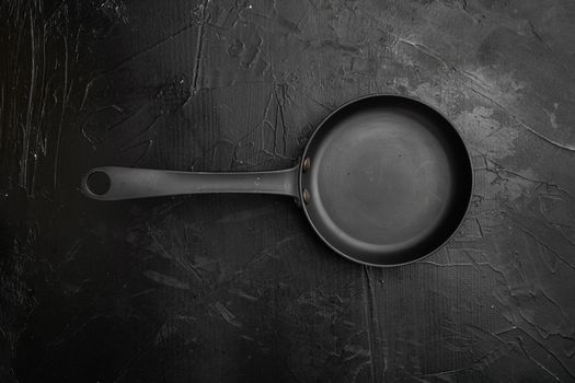 Large frying pan with copy space for text or food with copy space for text or food, top view flat lay , on black dark stone table background